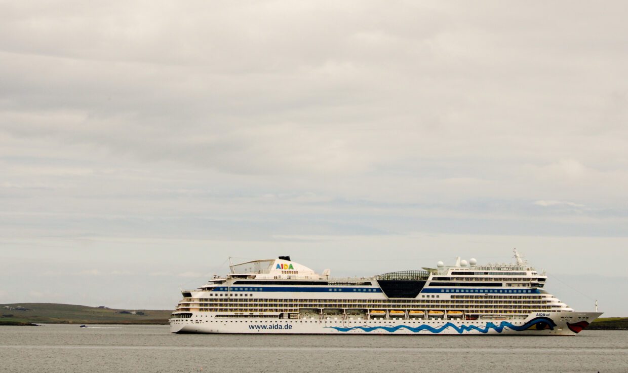 Cruise ship docked at Hatston Pier in Orkney with a painted smiling mouth and eyes on the hull